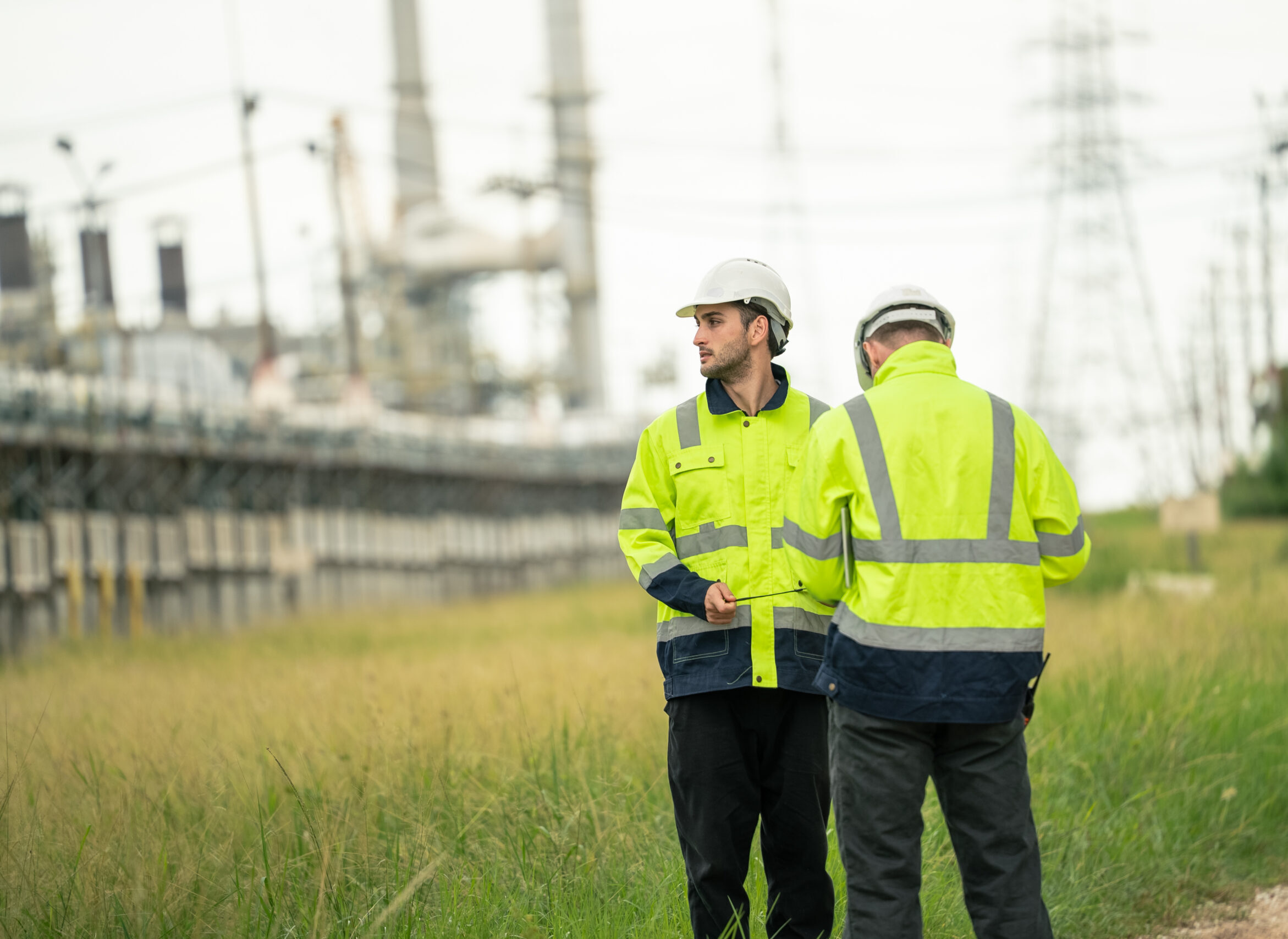 Engineer worker in protective uniform talking with colleagues at
